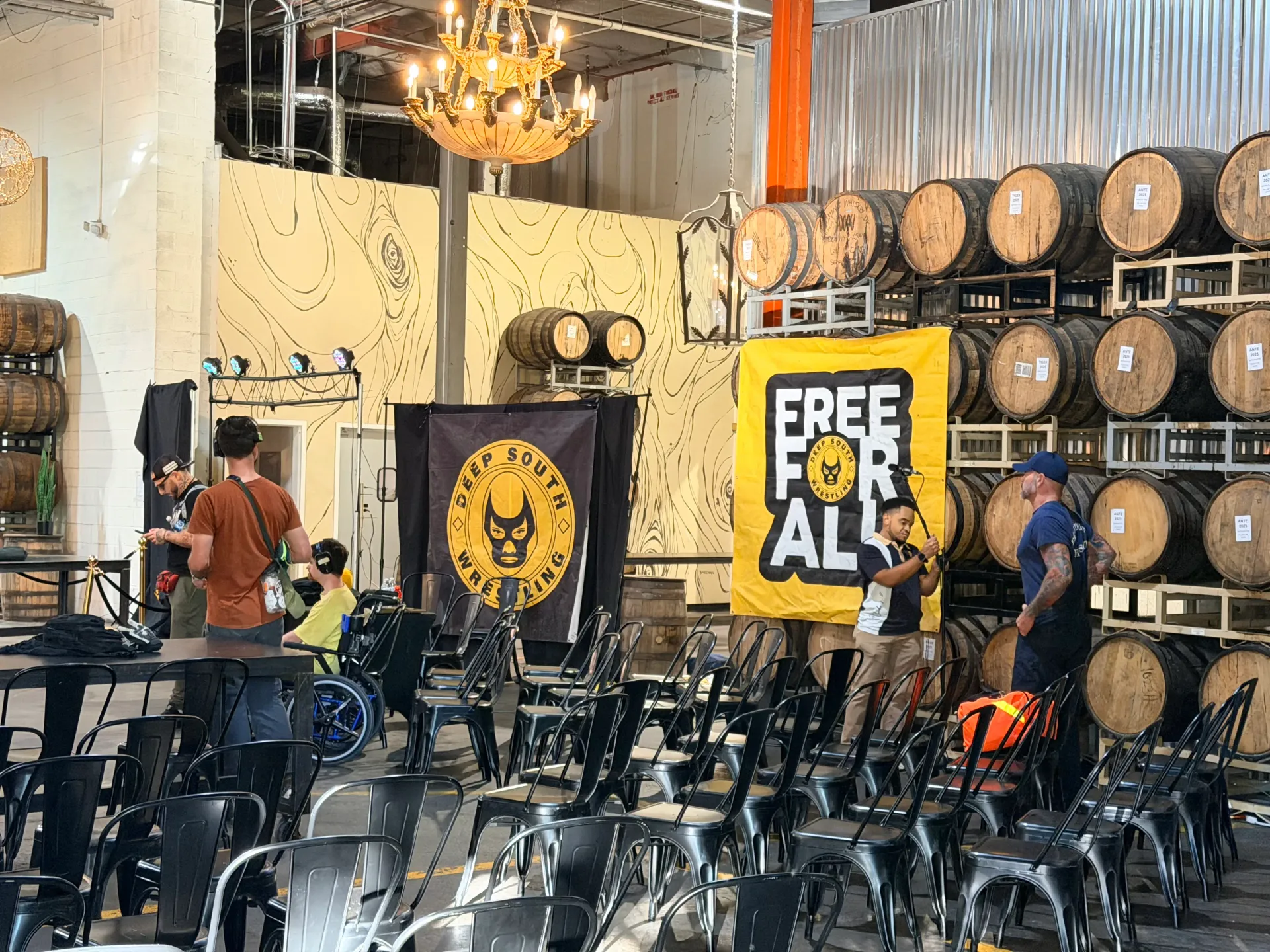 Deep South Wrestling event venue with rows of chairs, barrels, and Free For All banners